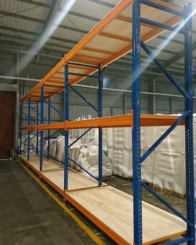 Rak besi heavy duty dan steel pallet bertingkat untuk penyimpanan stok barang berat berkapasitas besar di gudang.